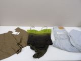 Trois paires de pantalons pour homme sont posées sur une table blanche