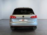 the rear end of a silver volkswagen vw parked in a white room