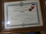 a framed picture of a medal and a medal on a table