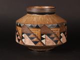 a brown vase with geometric designs on it on a black background