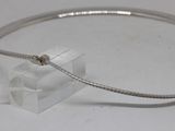 silver plated bracelet with a snake clasp on a clear acrylic block