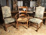plusieurs chaises et une table dans une pièce avec une cheminée en arrière-plan
