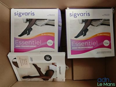 deux boîtes de collants pour femmes posées sur une boîte en carton