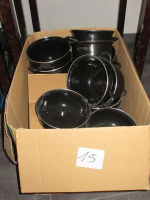 une caisse remplie de casseroles et de poêles posée par terre