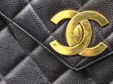 a close up of a chanel bag with a gold logo on it