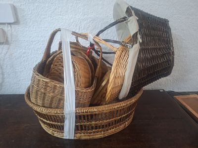 un panier en osier rempli d'assiettes et de couverts posé sur une table