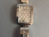 wrist watch on a table with a white napkin and a silver watch