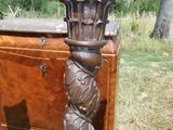 une commode en bois surmontée d'une colonne sculptée