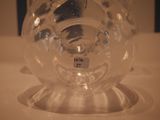 a glass vase with a label on it sitting on a table