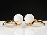 pair of gold and white pearl earrings on a white surface