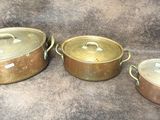 three pots and pans sitting on a table