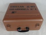 a brown suitcase sitting on a white surface with a black handle