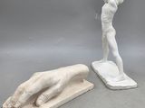 une statue représentant un homme tenant une batte de baseball, à côté d'une statue représentant une main tenant une batte de baseball