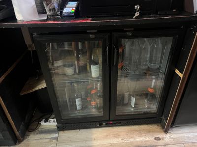 bottles of wine are sitting in a glass case in a store