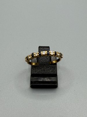 une image représentant une bague en or posée sur un socle noir