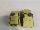 two toy army vehicles that are sitting on a table