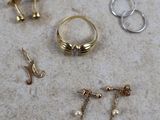 Trois paires de boucles d'oreilles et une bague sont posées sur une table