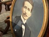 portrait d'un homme en smoking, assis sur une chaise dans une pièce