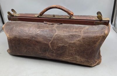 un sac en cuir marron posé sur une surface blanche