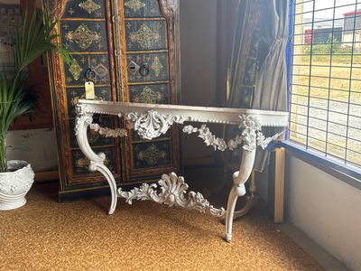 a white table with a mirror and a potted plant