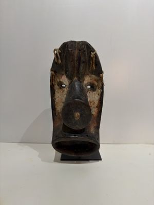 a wooden mask on display on a white table