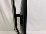 a black computer monitor on a stand on a white surface