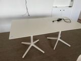a white table with two white legs and a white table top