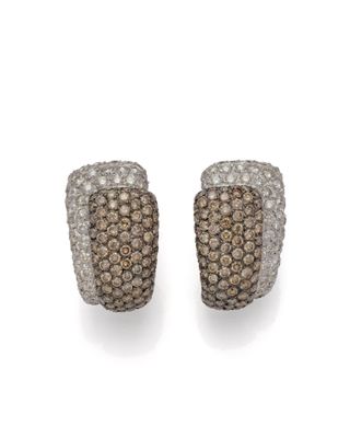 une paire de boucles d'oreilles en diamant marron et blanc sur fond blanc