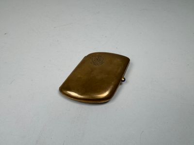 a small gold cigarette case sitting on a white table