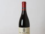 a bottle of red wine sitting on top of a wooden table