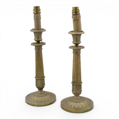 a pair of brass candlesticks on a white background