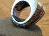 sterling silver ring on a wooden stand on a wooden surface