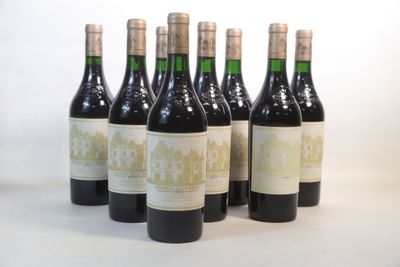six bouteilles de vin sont alignées sur une surface blanche