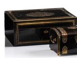 two black and gold boxes sitting next to each other on a white surface