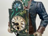a figurine of a man holding a clock in his hand