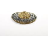 une broche en or et en argent sur un fond blanc