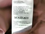 an image of a label on a pink jacket with a tag attached to it
