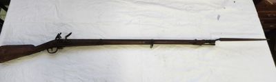 un vieux fusil est posé sur une feuille de papier