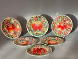 six colorful plates with designs on them sitting on a table