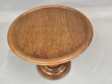 an image of a wooden table with a round top on a white surface