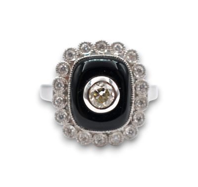 une image représentant une bague ornée d'une pierre noire entourée de diamants blancs