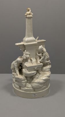 une statue représentant une fontaine autour de laquelle sont assises des personnes