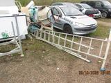a car that is parked next to a fence and a trailer