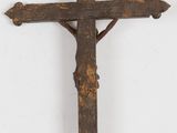 an old wooden cross hanging on a wall with a white background