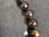 collier avec des perles marron sur une chaîne en or