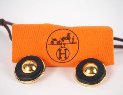 une paire de boucles d'oreilles posée sur une pochette orange