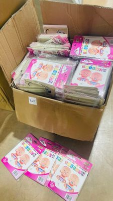 une boîte en carton remplie de couches pour bébés posée par terre