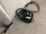 un aspirateur posé sur le sol à côté d'un mur