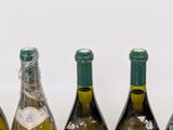 four bottles of wine are lined up on a table