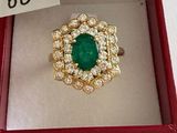 an emerald and diamond ring in a red box with a price tag